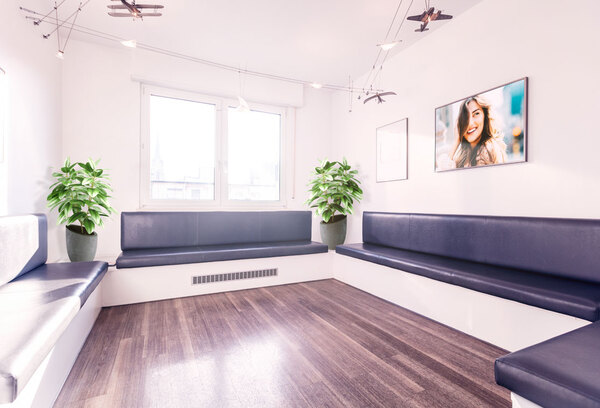 Heller Wartebereich mit modernen Sitzbänken, Zimmerpflanzen und freundlicher Atmosphäre.